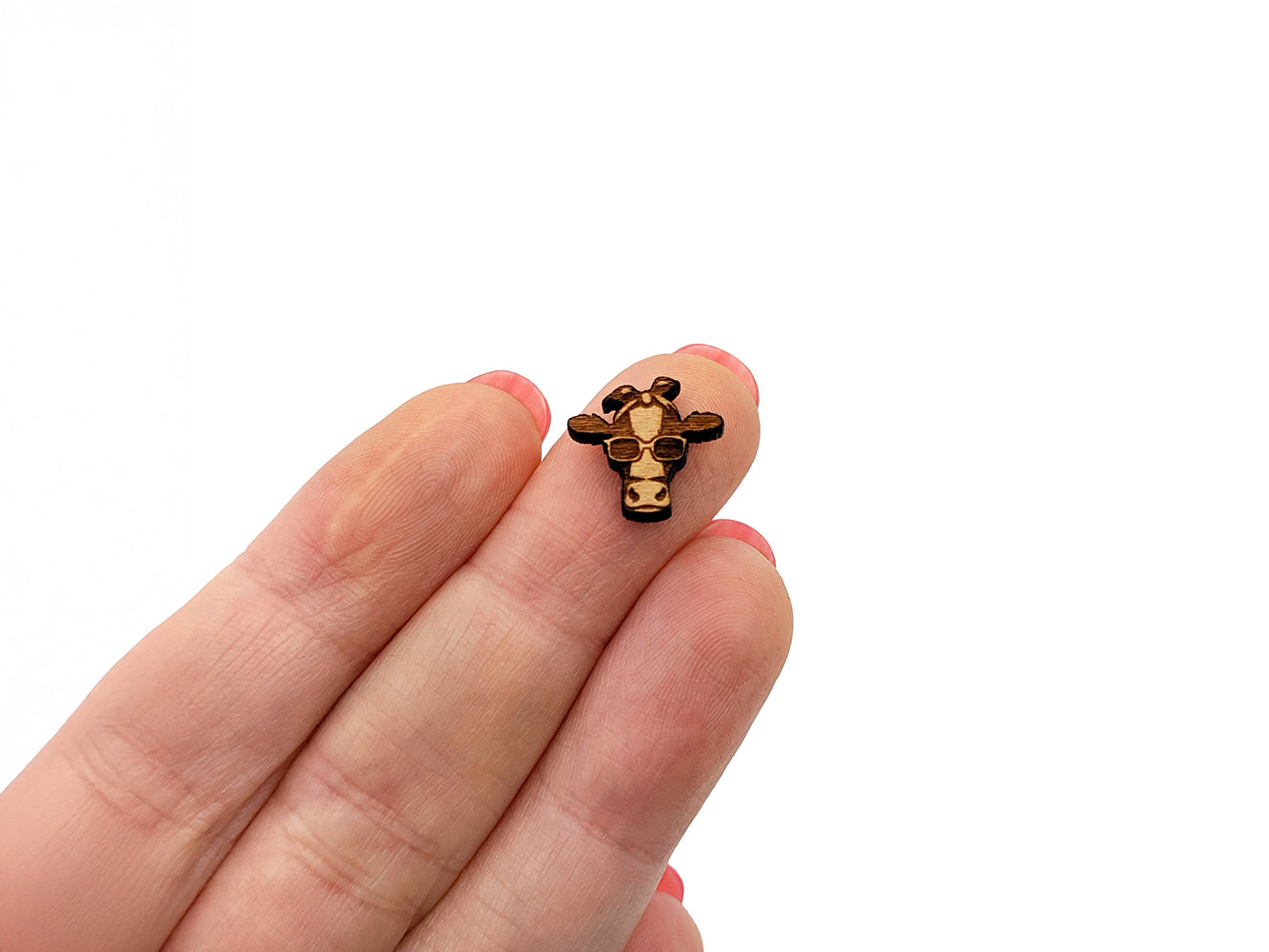 a person holding a tiny toy giraffe in their hand