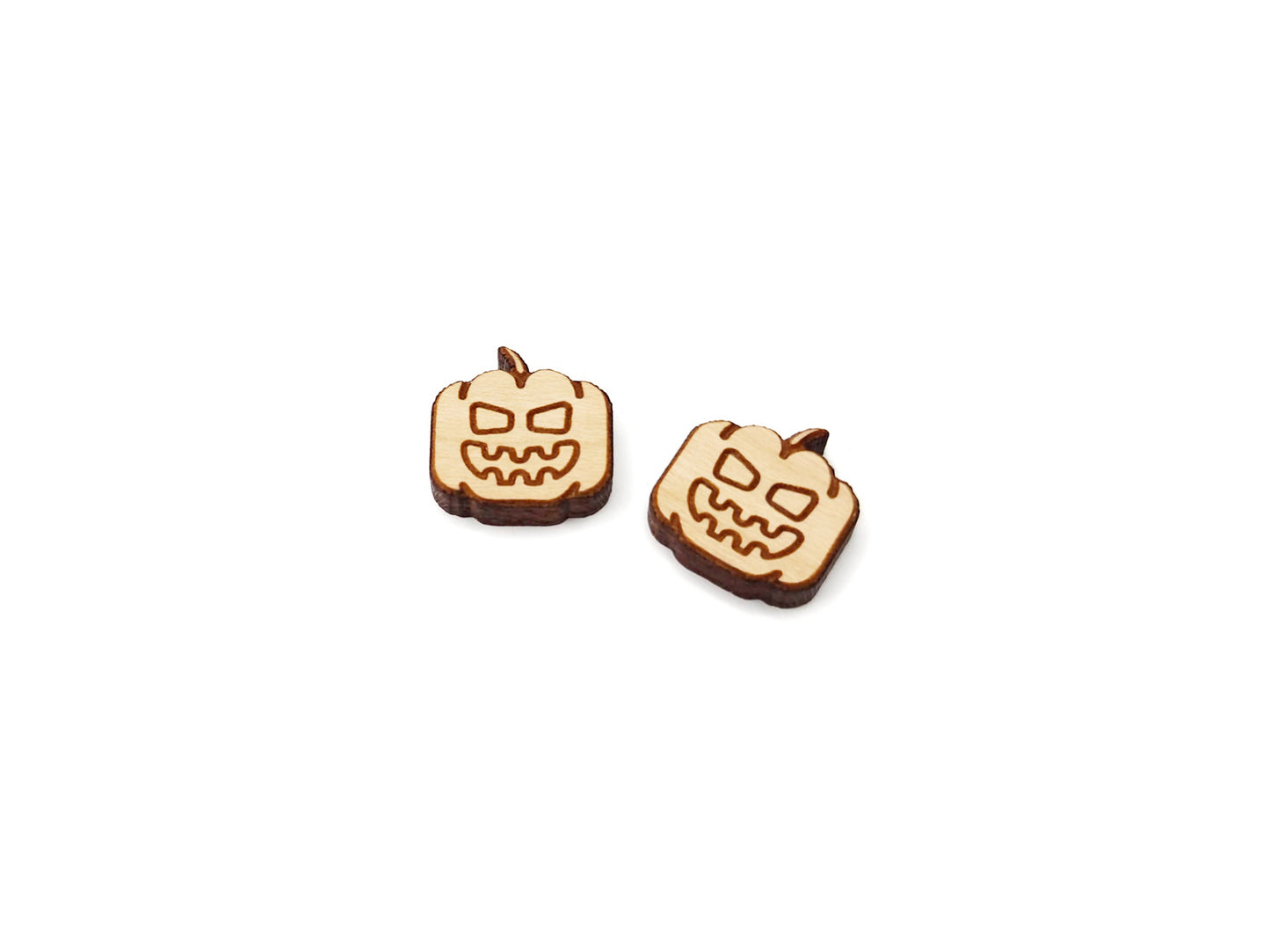a pair of wooden cabochon earring blanks cut and engraved to look like a jack-O-lantern