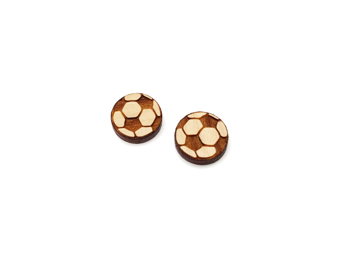 a pair of wooden cabochon earring blanks cut and engraved to look like a soccer ball