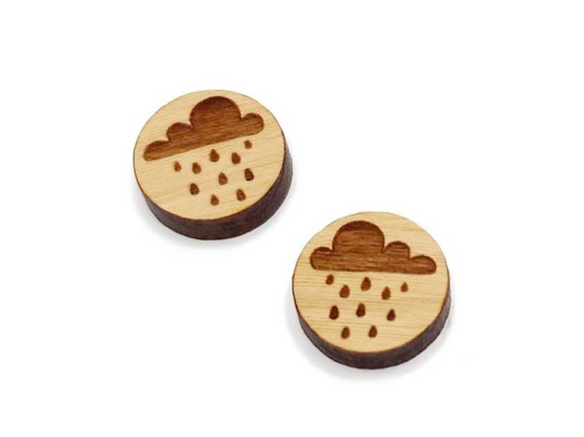 a pair of round wooden cabochon earring blanks engraved with a rain cloud design
