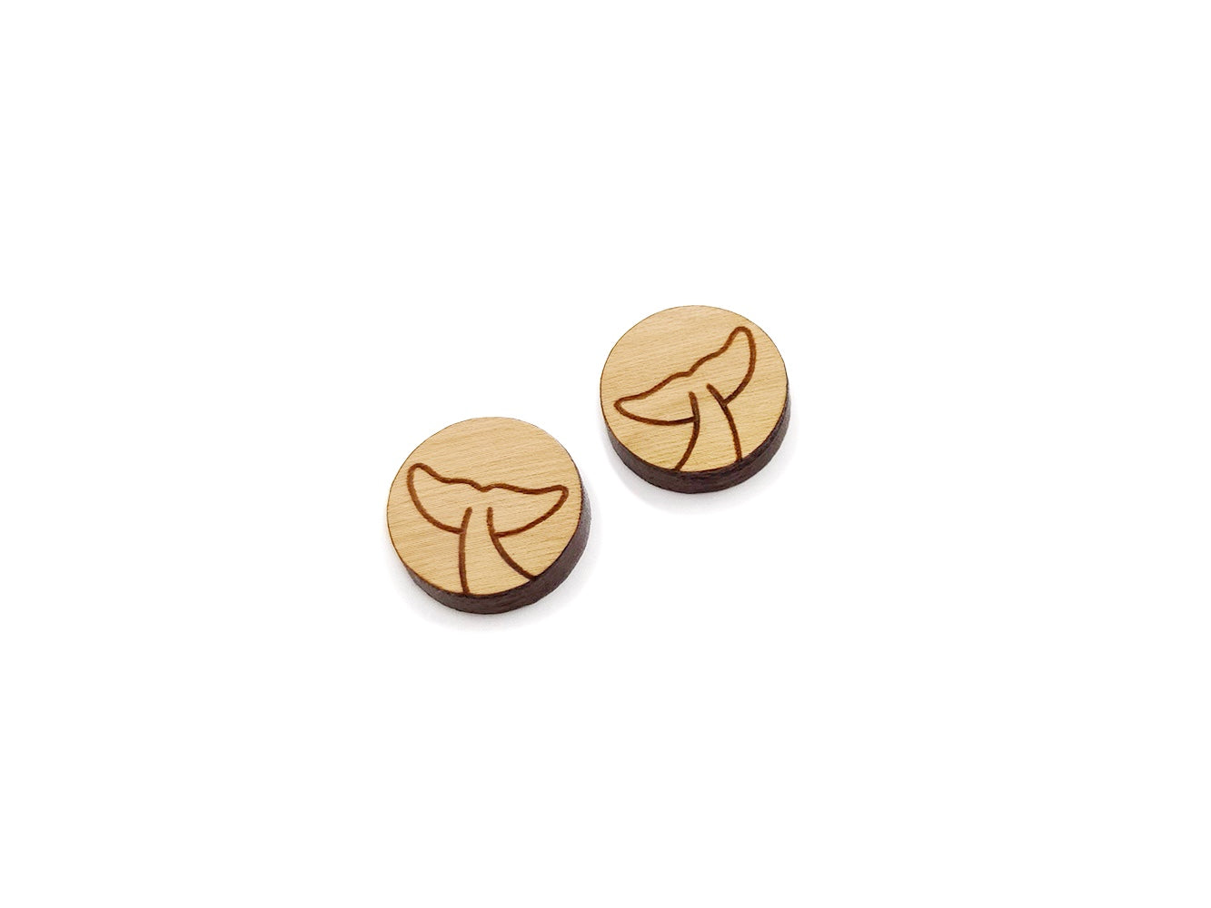 a pair of round wooden cabochon earring blanks engraved with a whale's tail