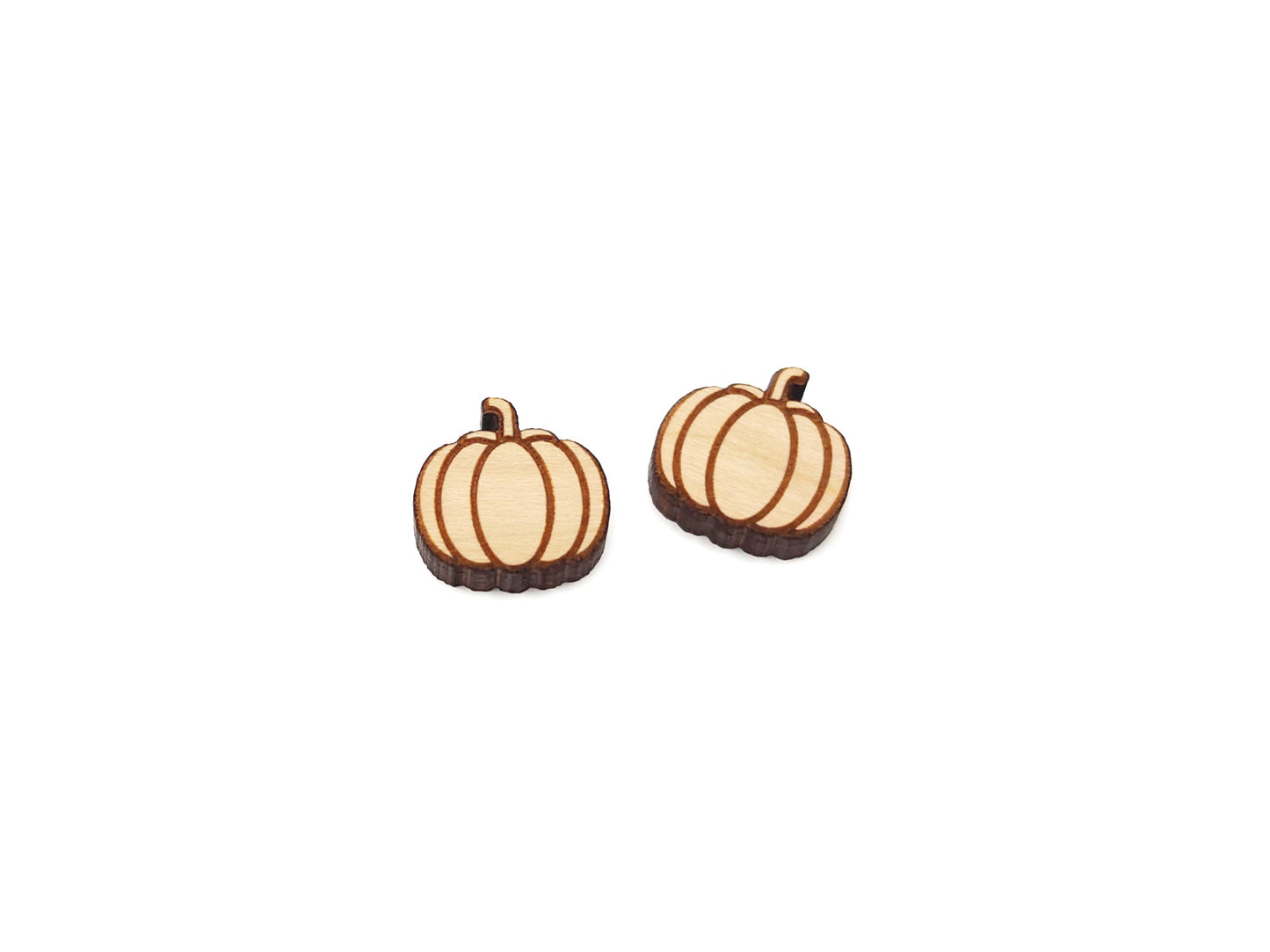 a pair of wooden cabochon earring blanks cut and engraved to look like a fall pumpkin