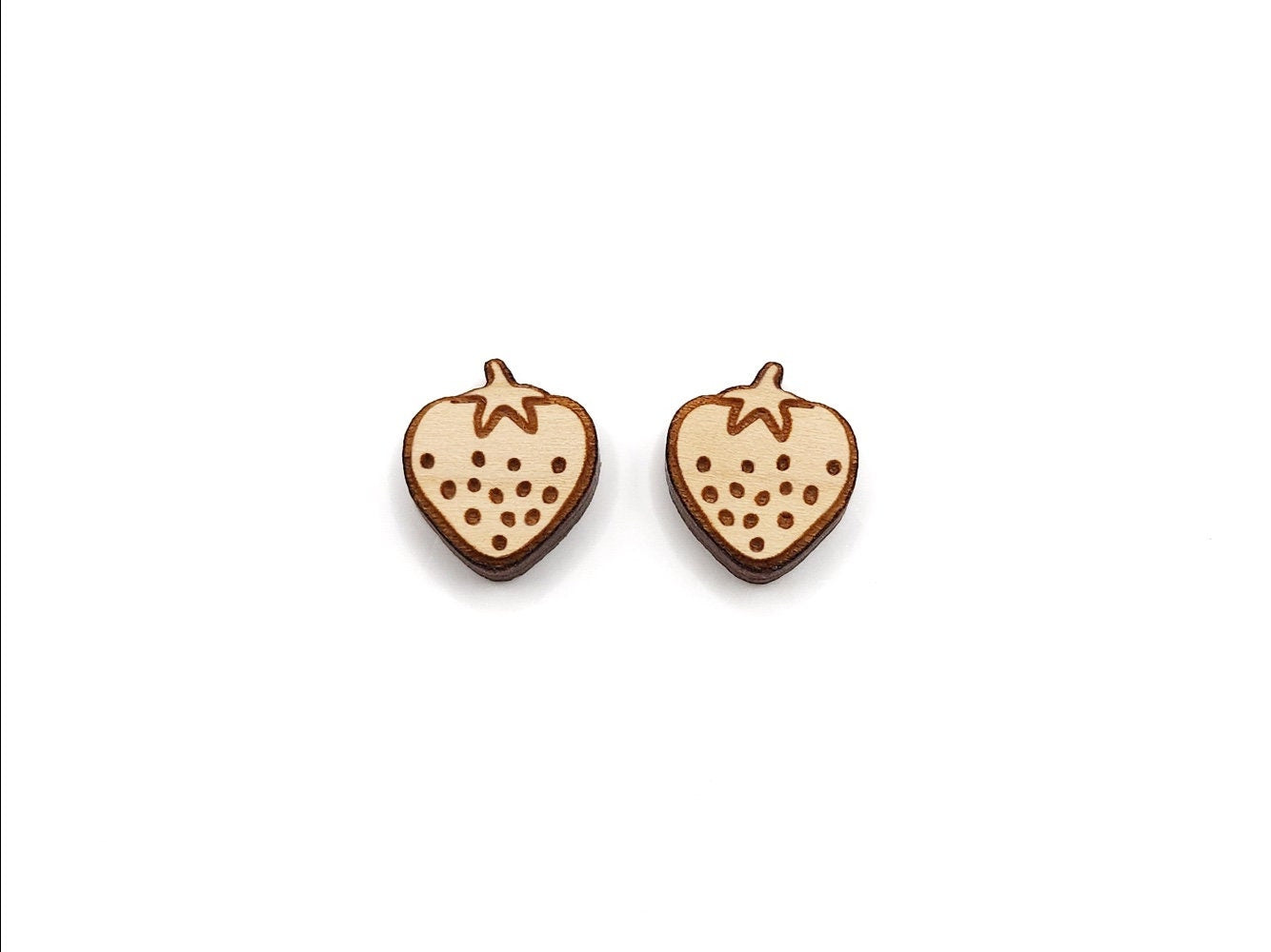 A pair of wooden cabochon earring blanks cut and engraved to look like a strawberry.