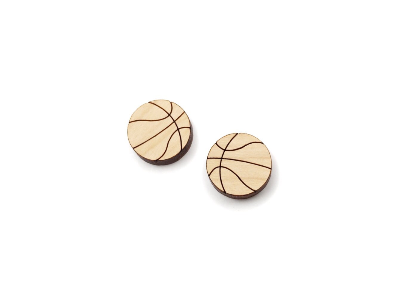 a pair of wooden cabochon stud earring blanks cut and engraved to look like basketballs