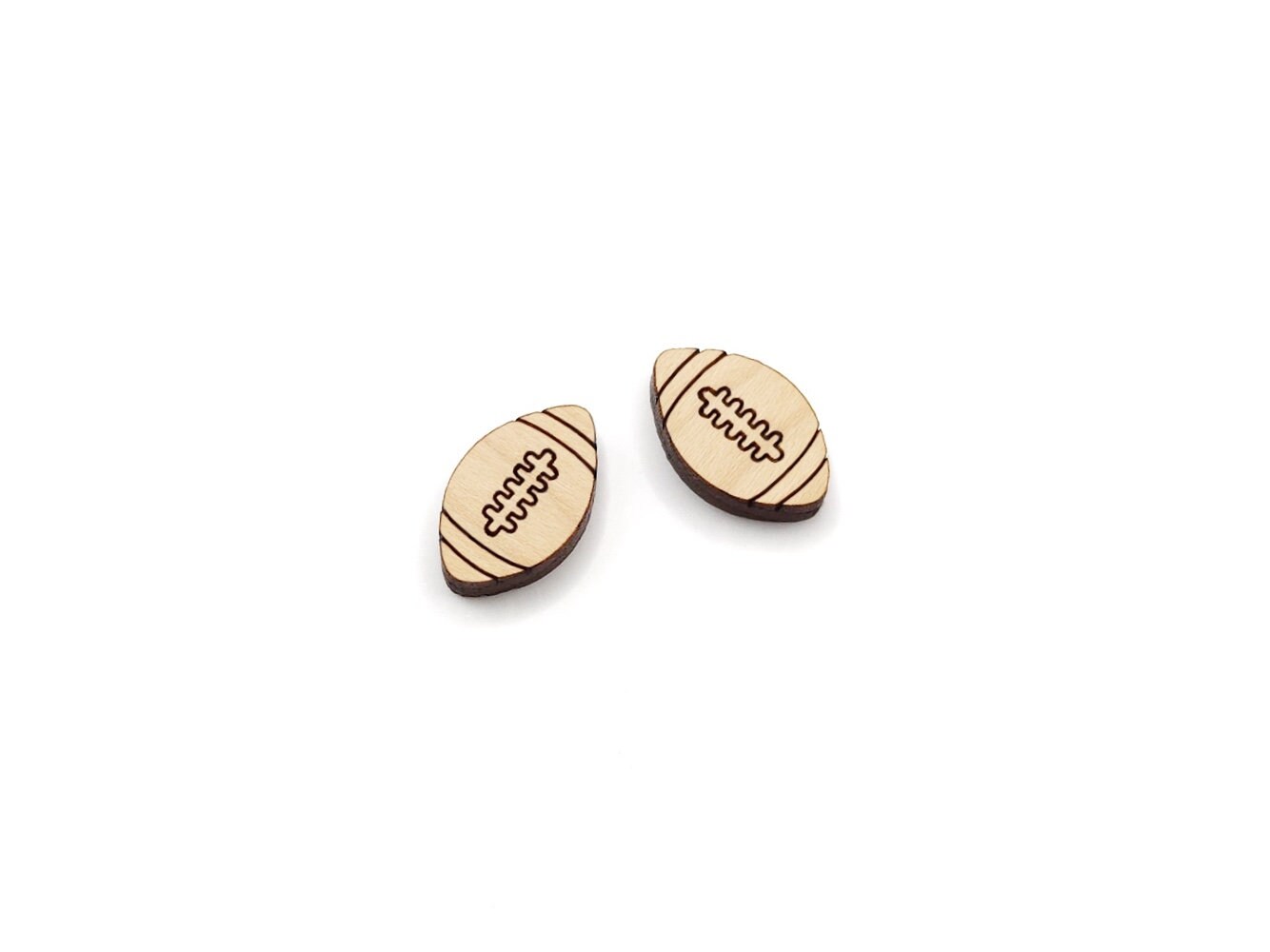 a pair of wooden cabochon stud earring blanks cut and engraved to look like footballs