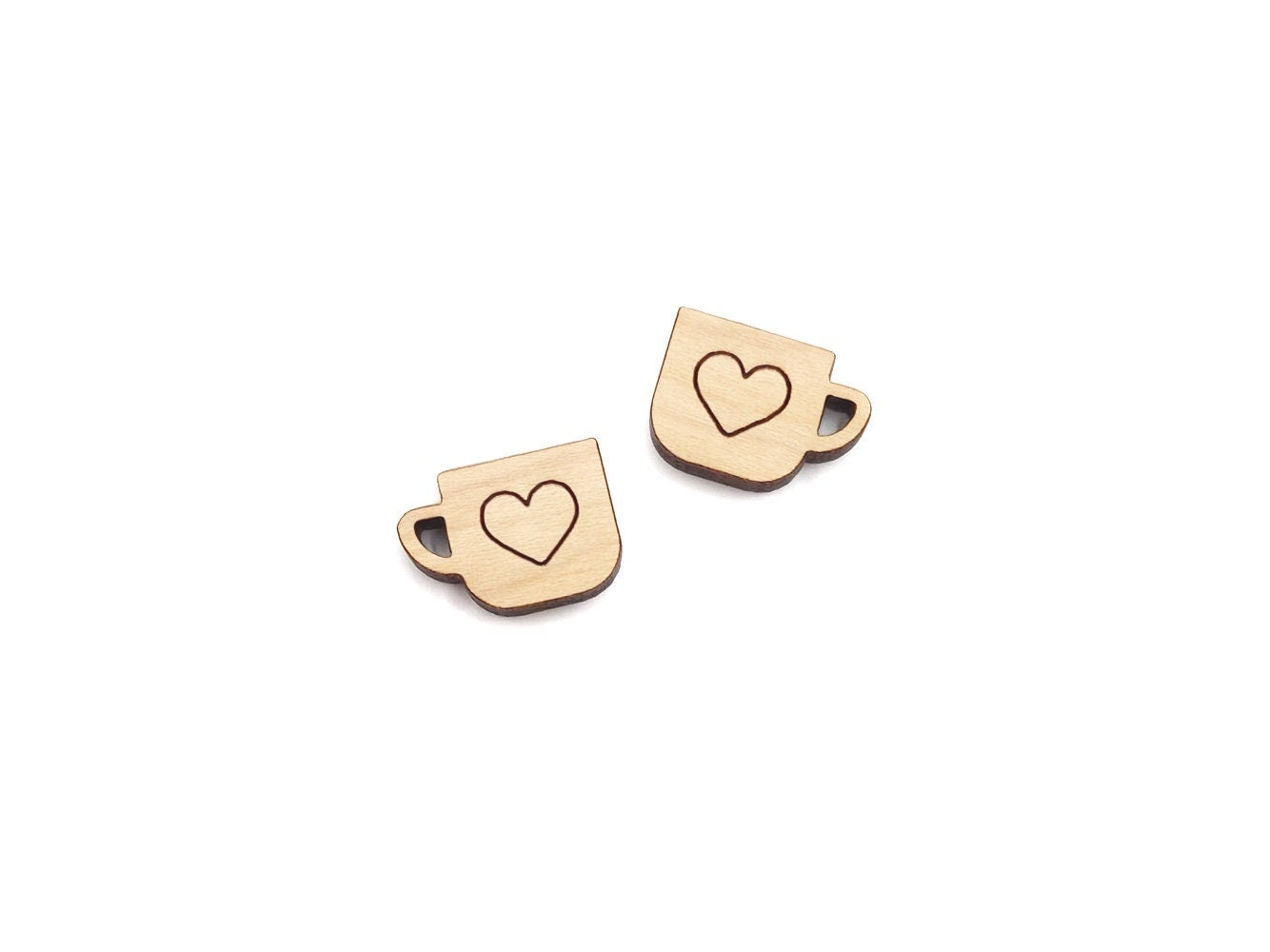 a pair of wooden cabochon stud earring blanks cut and engraved to look like mugs with a heart outline