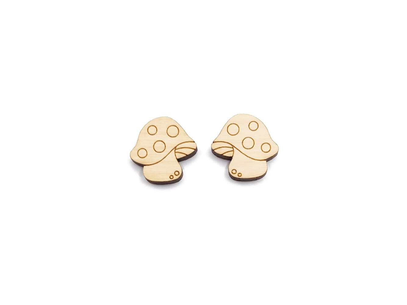 a pair of wooden cabochon stud earring blanks cut and engraved to look like spotted mushrooms