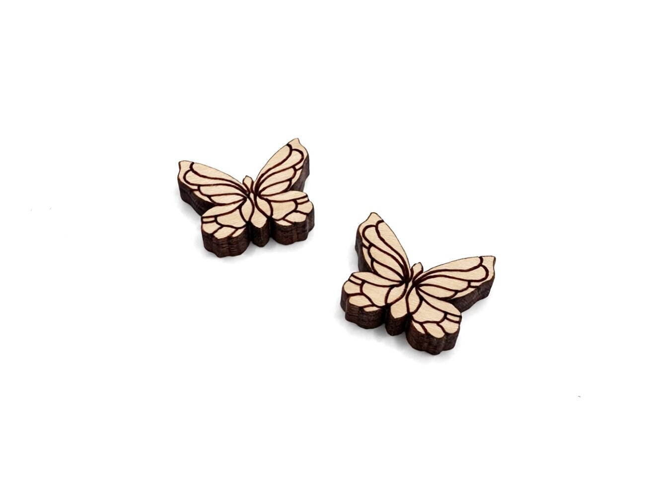 a pair of wooden cabochon stud earring blanks cut and engraved to look like butterflies