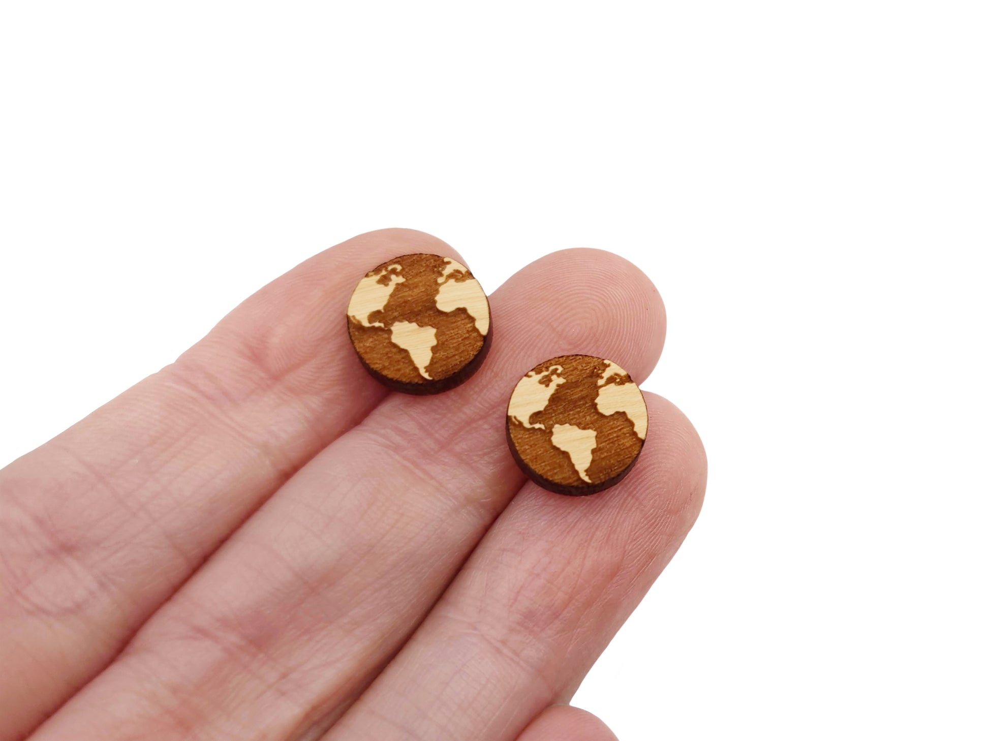 a hand holding a pair of small wooden earrings