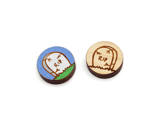 a pair of round wooden cabochon earring blanks engraved with a Halloween Tombstone