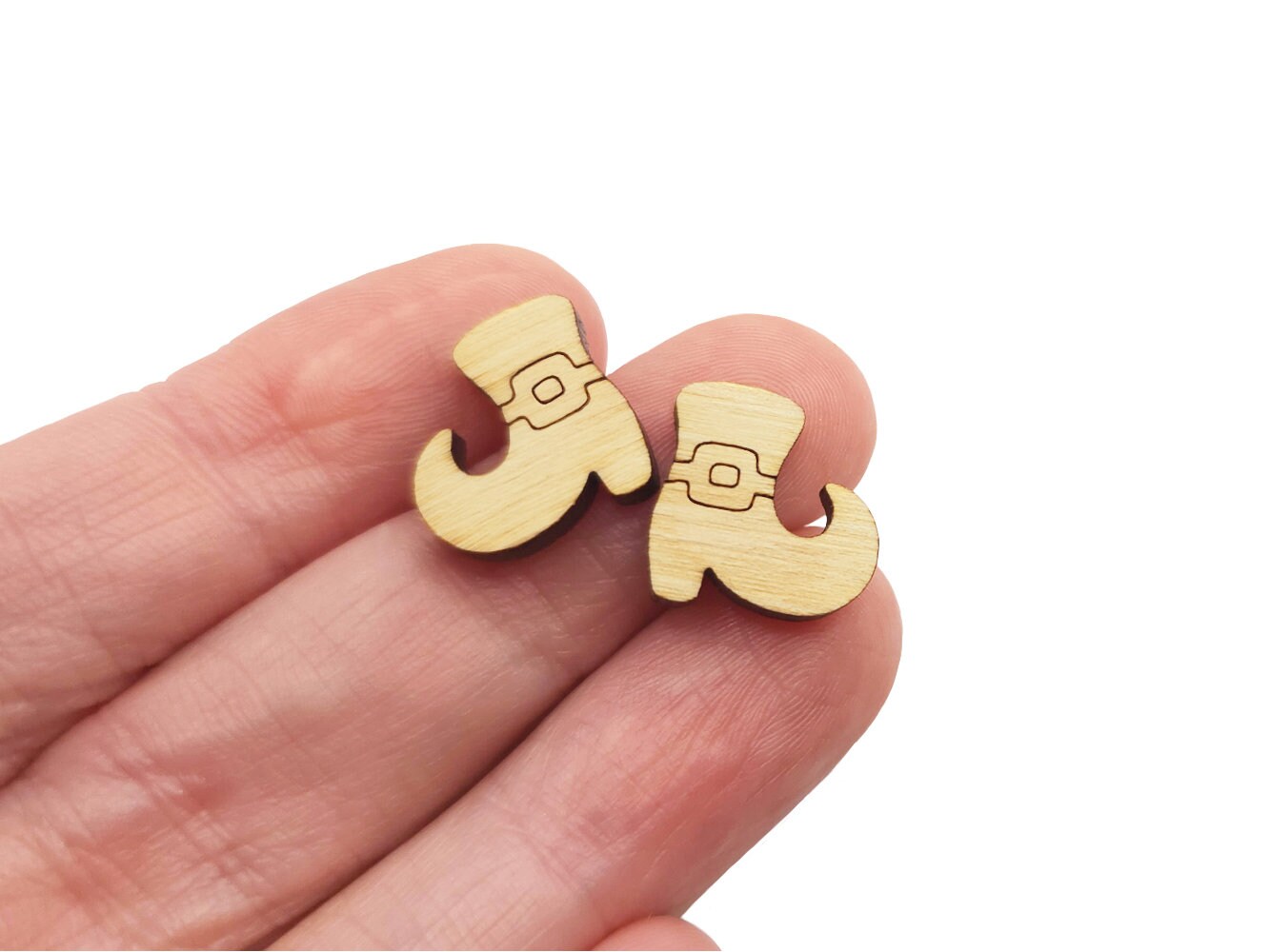 hand holding a pair of wooden cabochon earring blanks cut and engraved to look like Halloween witch shoes