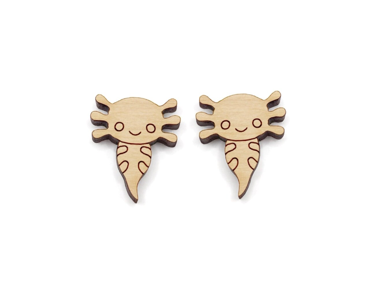 a pair of wooden cabochon stud earring blanks cut and engraved to look like axolotls